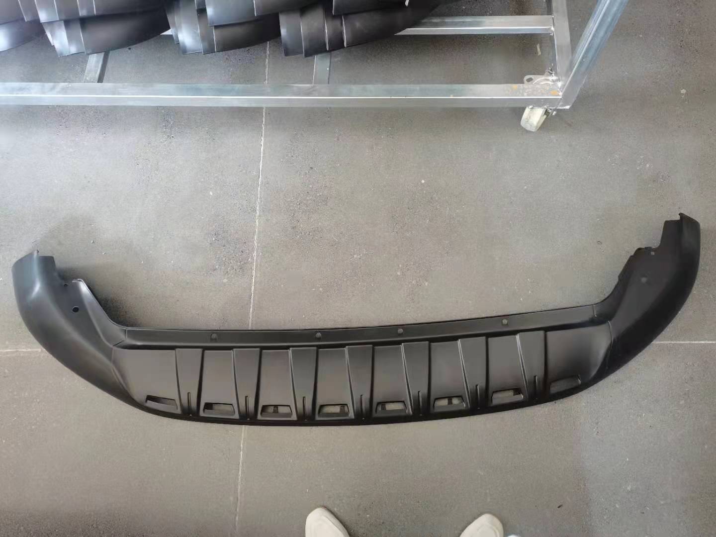 Under the front bumper